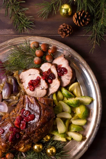 Plateau d'un repas de fête, rôti tranché aux canneberge, figues, noisettes et chou de bruxelles